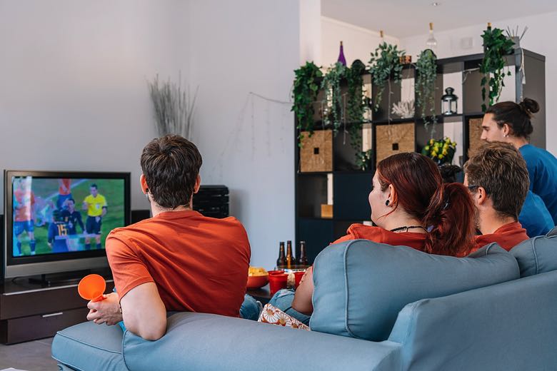 A group of friends watching a football match at home