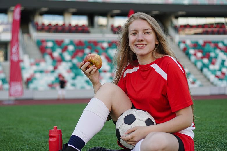 Football fan with food, drink and a jersey at a football match