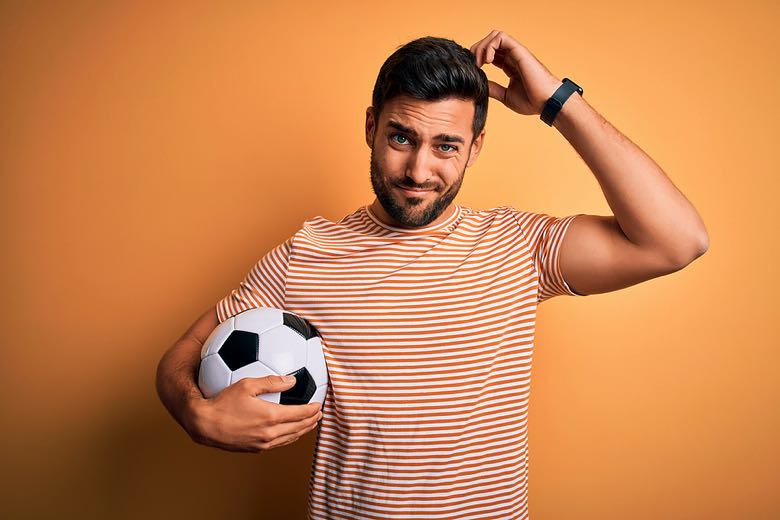 Confused man holding football