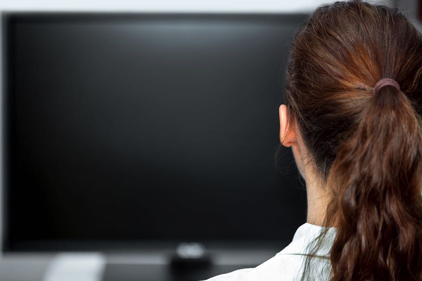 Young woman staring at black television