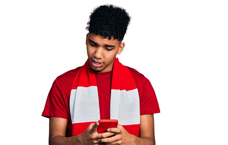 Confused young man holding mobile phone