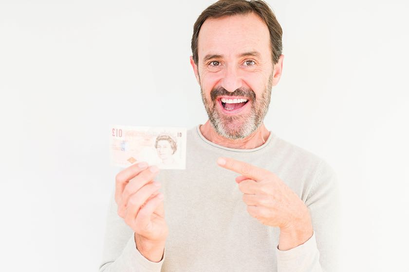 Man holding £10 note