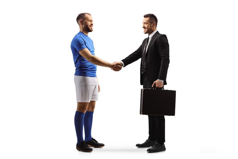Football scout shaking hand of footballer