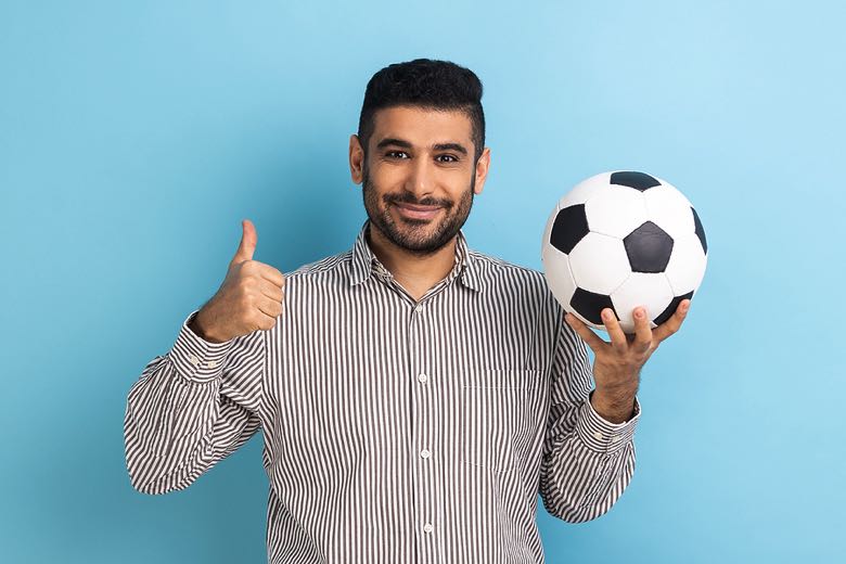 Man holding a football with a thumbs up