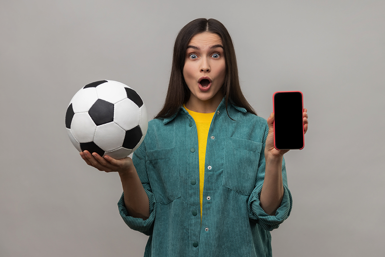 Woman holding phone with football