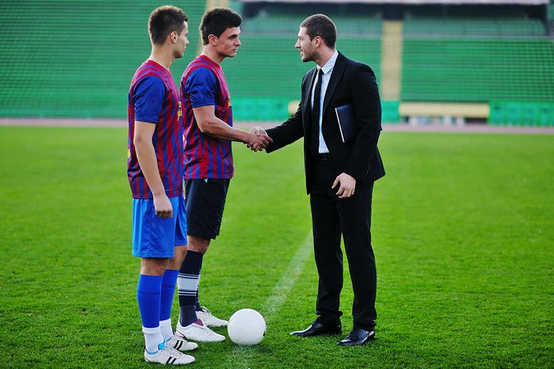 Football manager shaking hands with players