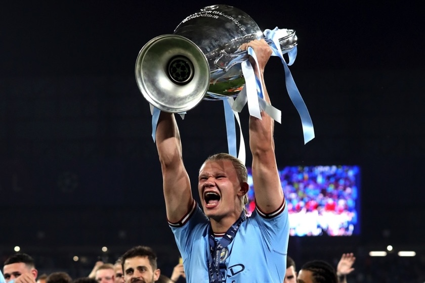 Haaland celebrating by holding up trophy