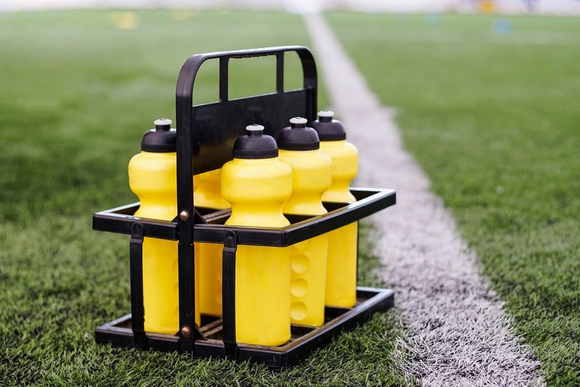 Yellow Water Bottles on Football Pitch