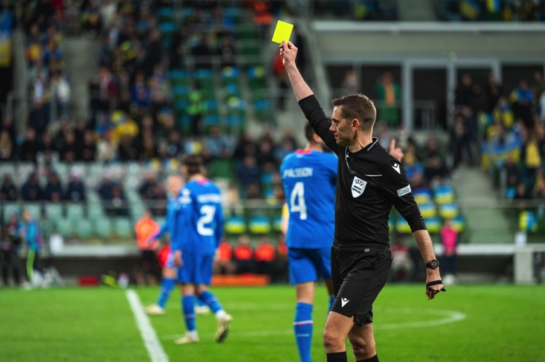Referee holding up yellow card