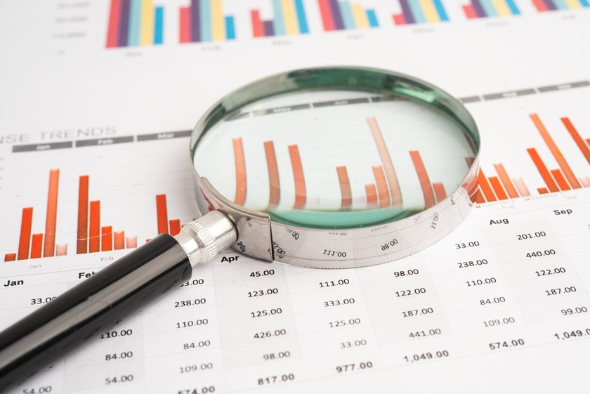 Magnifying Glass on Red Bar Chart Paperwork